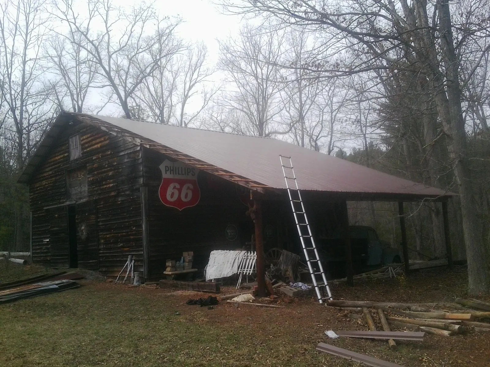 New metal roof on an open sided timber barn with a vintage sign in Brattleboro