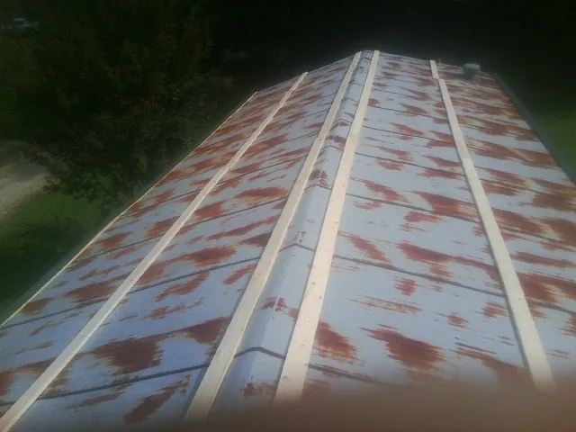 Rusted metal roof panels with new wood purlins before replacement — Storm Damage Roof Repair in Brattleboro by Roofing Brothers