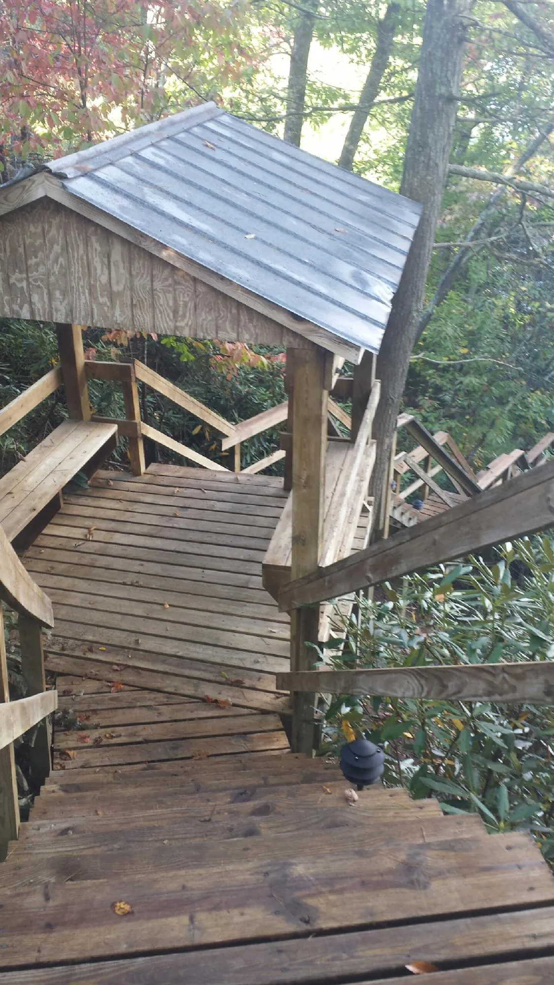 Metal roofed shelter over wooden steps on a wooded walkway — Skylight Repair & Installation work by our crew in Brattleboro