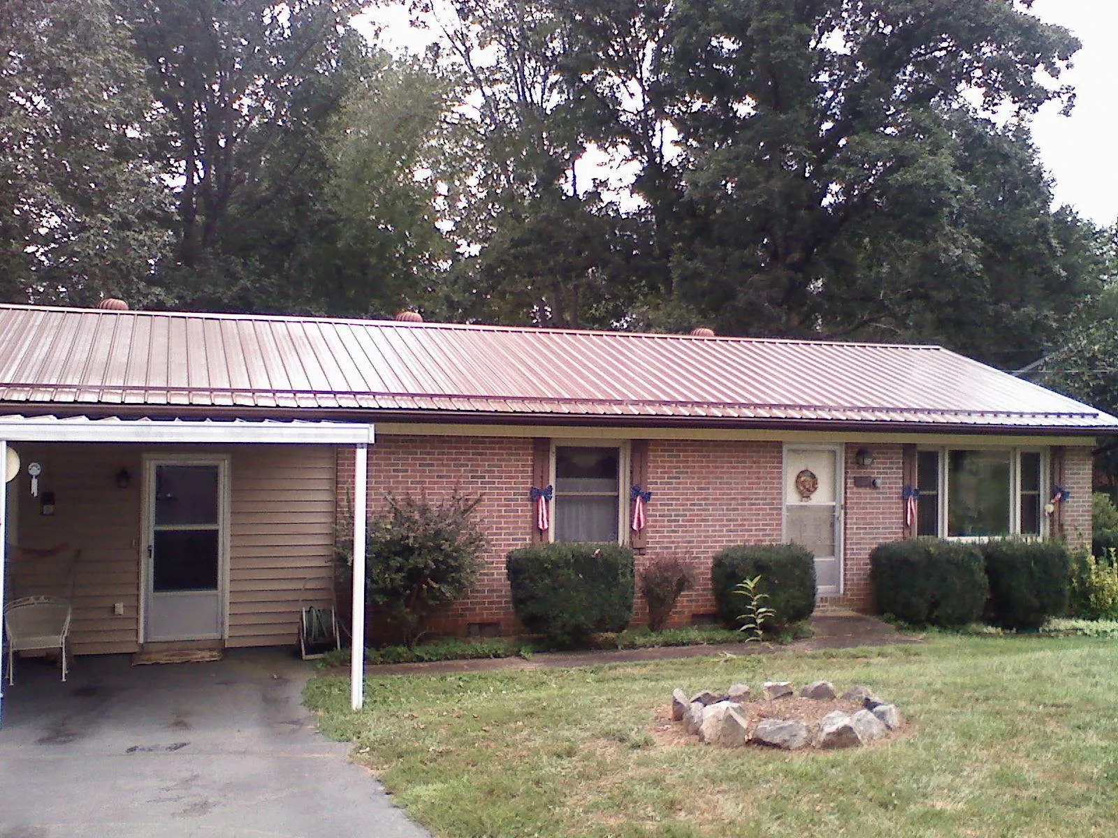 Bronze metal roof and carport on a brick ranch home — Roof Repair work by our crew in Brattleboro