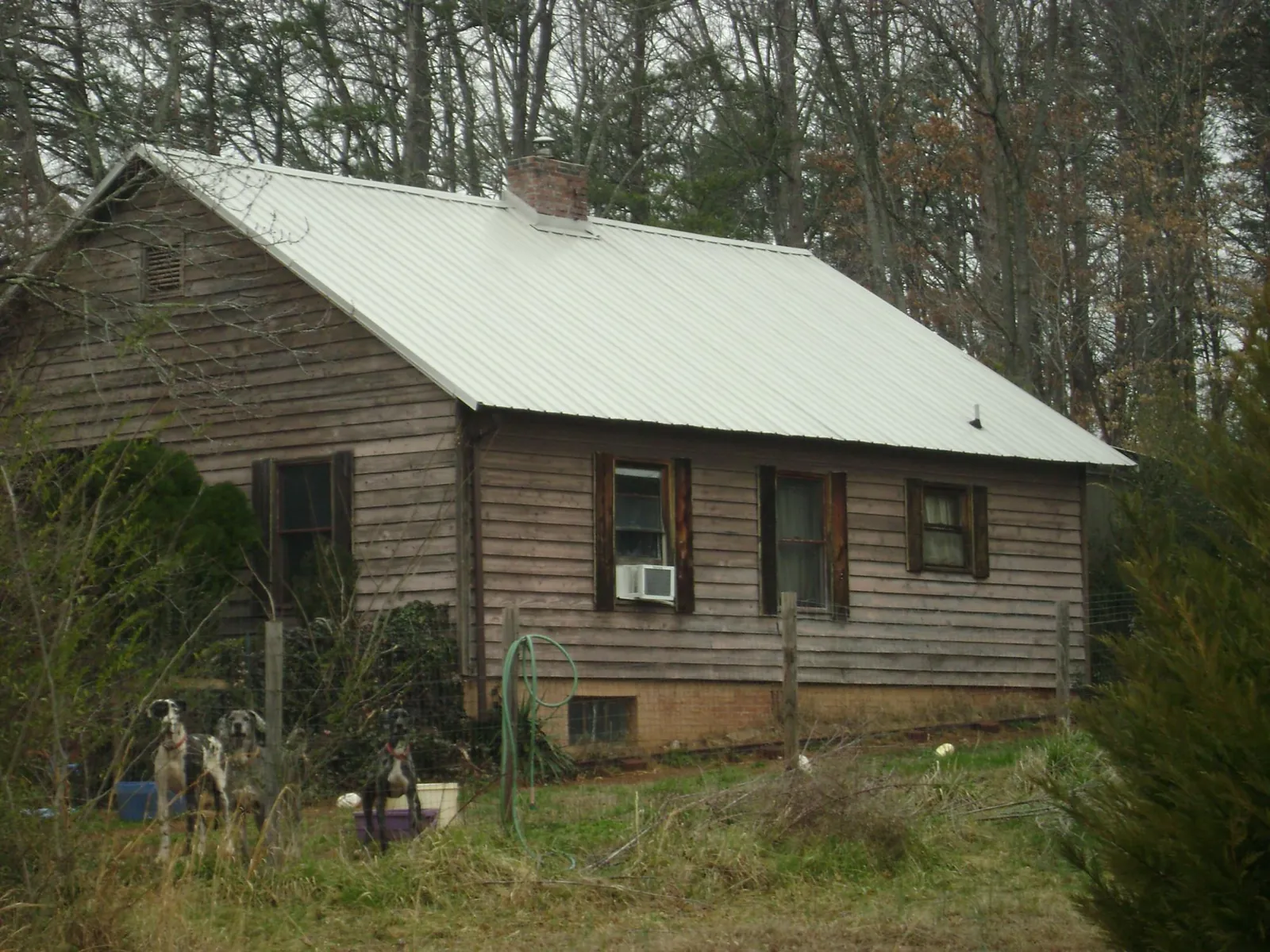 White metal roof on an old wood sided farmhouse, from a Metal Roof Installation job in Brattleboro